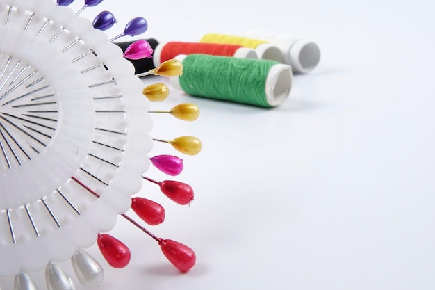 Igła i kolorowe nici na lnianej tkaninie